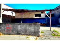 Terreno com casa modesta, chalés e construção em andamento, ocupado