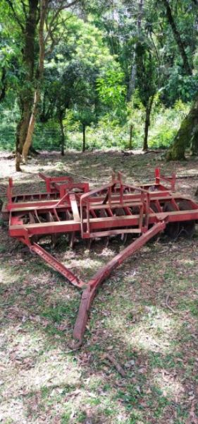 Grade aradora vermelha com 20 discos, apta para uso agrícola