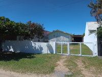 Terreno urbano com casa de madeira e garagem em Imbituba
