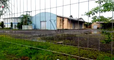 Terreno com prédio em alvenaria, depósitos e benfeitorias